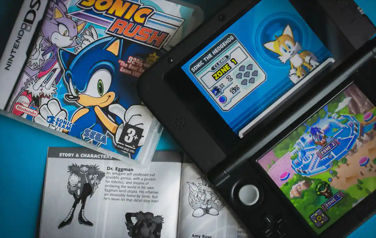 Nintendo 3DS e cartucho em flat lay sobre fundo azul